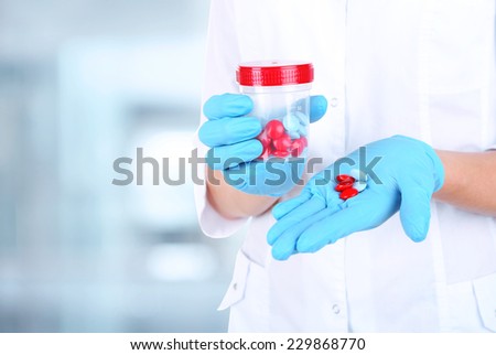 Doctor with pills on hospital background