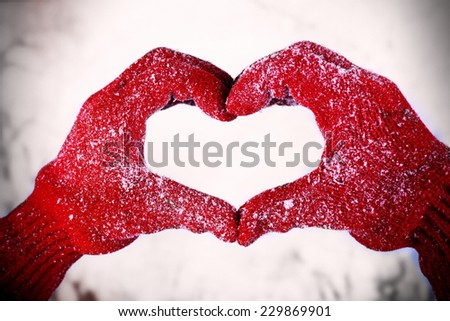 Woman\'s hands in red gloves on winter natural background