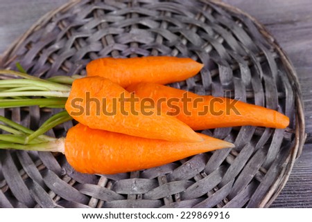 Carrots on round wooden mat on wooden background