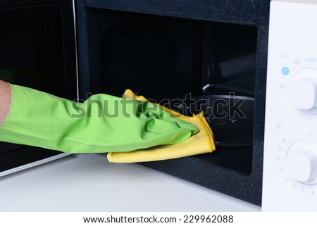 Cleaning microwave oven in kitchen close-up