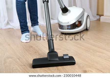 Woman with vacuum cleaner in room