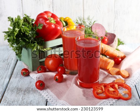 Vegetable juice and fresh vegetables on napkin on wooden table on wooden wall background
