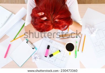 Tired woman over project on table