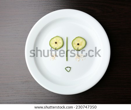 Vegetable face on plate on wooden table