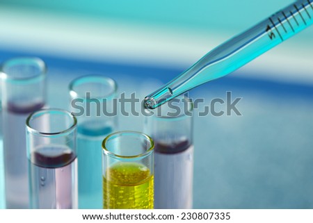 Test-tubes with liquid on color background. Drops from test stick
