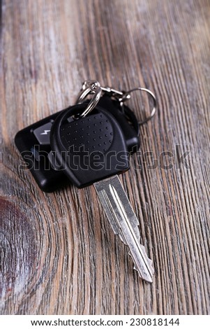 Car key with remote control on wooden table, close-up