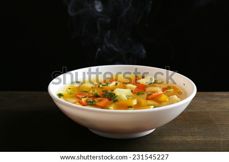 Delicious home cooked food with steam on table on black background