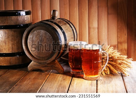 Beer barrel with beer glasses on table on wooden background