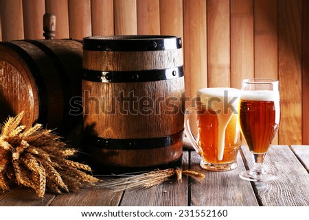 Beer barrel with beer glasses on table on wooden background