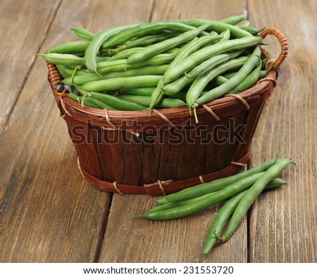 French beans in wooden basket on table close-up