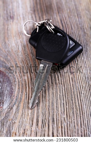 Car key with remote control on wooden table, close-up