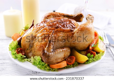 Delicious baked chicken on plate on table on light background