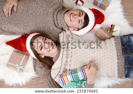 Happy couple with Christmas gifts relaxing at home