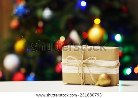 Gift box on Christmas tree lights background