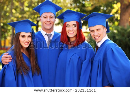 Graduate students wearing graduation hat and gown, outdoors