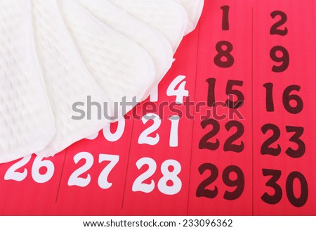 Sanitary pads on red calendar background