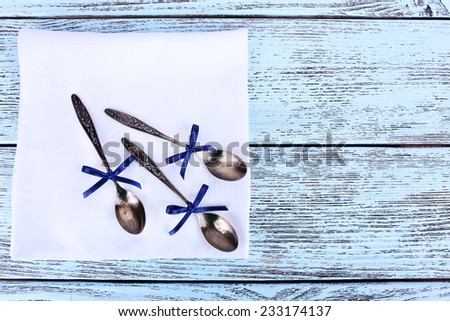 Metal spoons on white napkin on wooden background