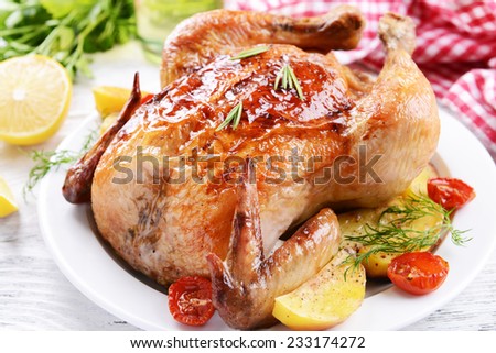 Delicious baked chicken on plate on table close-up
