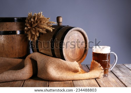 Beer barrel with beer glass on table on grey background