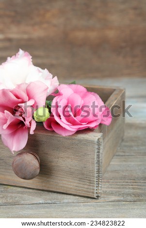 Beautiful eustoma flowers in box on wooden background