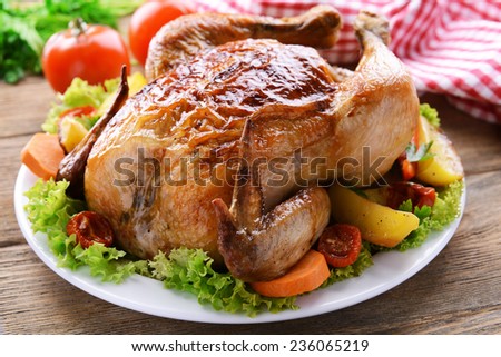 Delicious baked chicken on plate on table close-up
