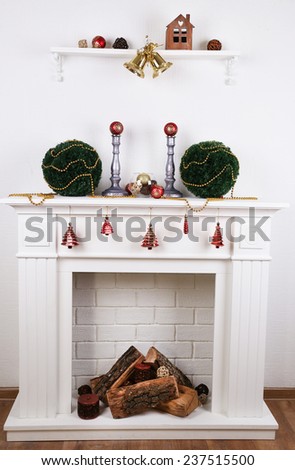 Fireplace with Christmas decoration on wooden floor near white background