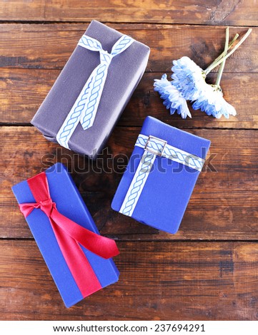 Three present boxes with flowers on wooden background