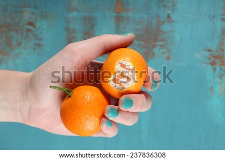Hand holding ripe tangerines, close up