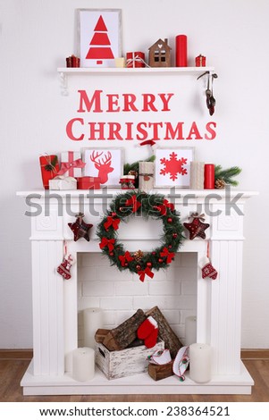 Fireplace with Christmas decoration on wooden floor and white wall background