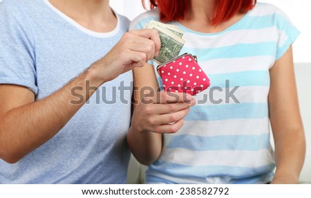Loving couple sitting in sofa with purse in room