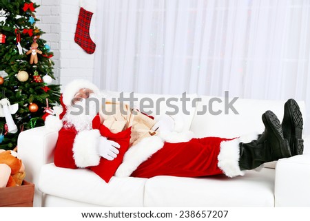 Santa Claus sleeping at home near Christmas tree
