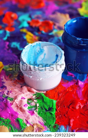 Cans of paint on colorful painted background