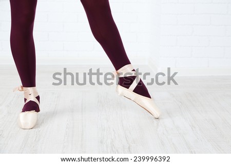 Ballerina in pointe shoes in dance hall