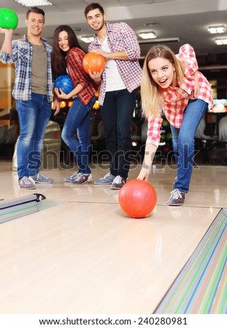 Young friends playing in bowling alley