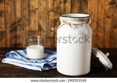 Open milk can on dishcloth on rustic wooden background