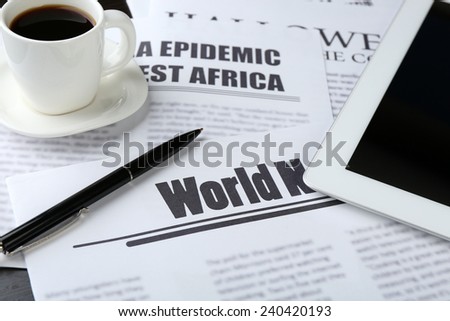 On-line news concept. Computer mouse, PC tablet, cup of coffee and newspaper, close-up