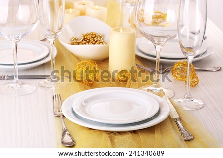 Beautiful holiday table setting in white and gold color