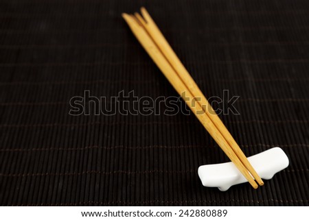Pair of chopsticks on black bamboo mat background
