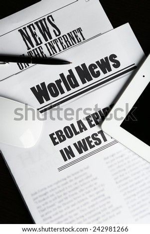 On-line news concept.Computer mouse, PC tablet and newspaper, close-up