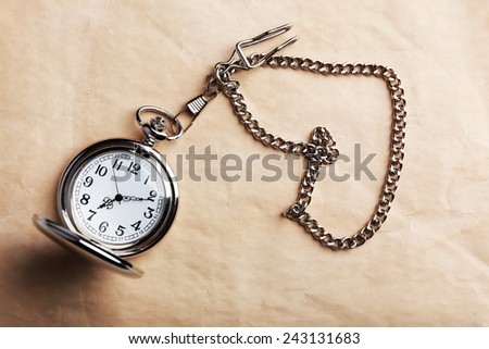 Silver pocket clock on old paper background