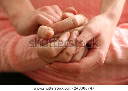 Old and young holding hands, closeup