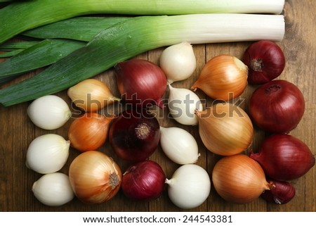 Different raw onion on wooden background