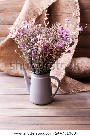 Bouquet of dried flowers on table and wooden planks background
