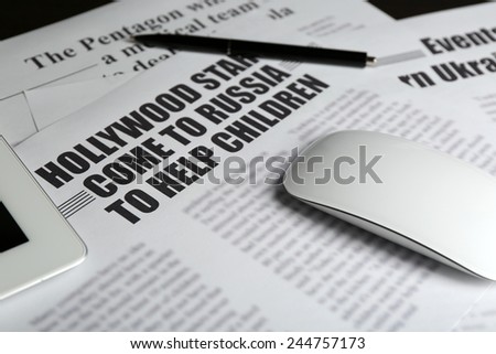 On-line news concept.Computer mouse, PC tablet and newspaper, close-up