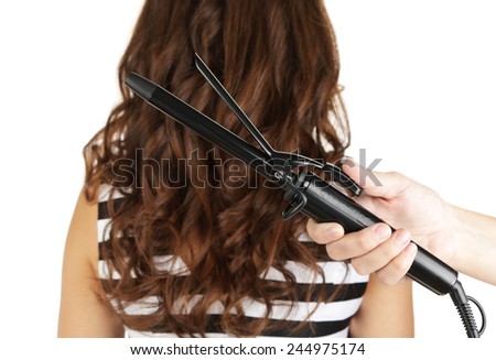 Stylist using curling iron for hair curls, close-up, isolated on white