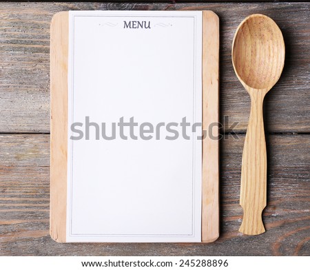 Cutting board with menu sheet of paper on rustic wooden planks background