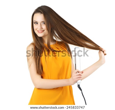 Beautiful young woman with long hair using hair straighteners isolated on white
