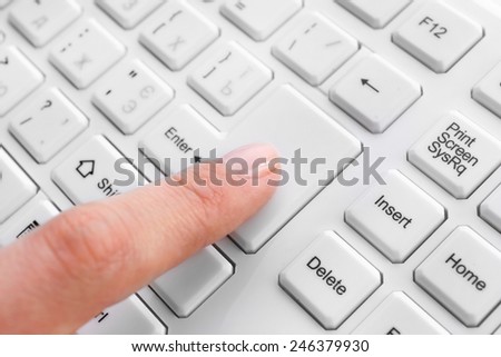 Female finger typing on keyboard, macro view