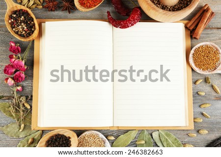 Spices with recipe book on rustic wooden table background