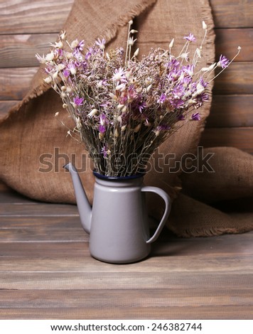 Bouquet of dried flowers on table and wooden planks background